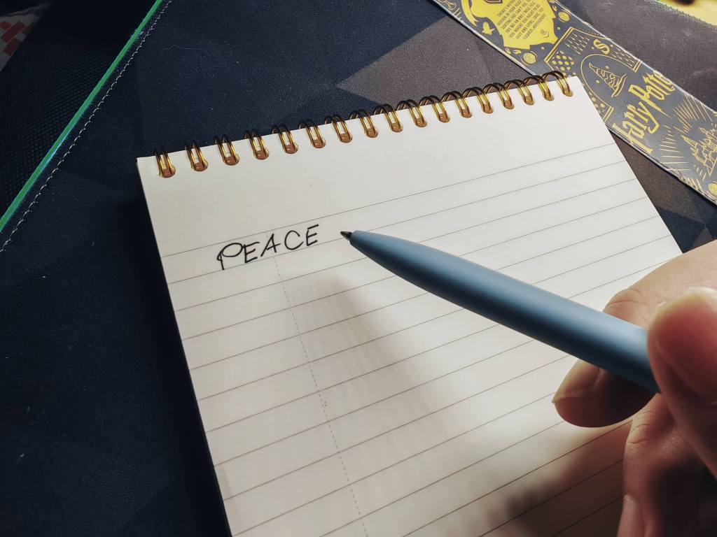 a handwritten word with the word PEACE on a blank sheet of paper